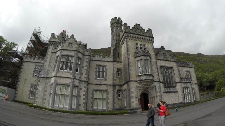 A person standing in front of a castle. Description generated with very high confidence