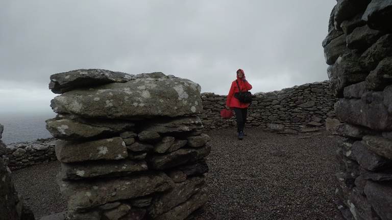 A person standing in front of a large rock